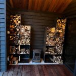 set of 18 steel log boxes stacked up full of kindling and logs in a wooden shelter outdoors