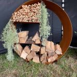 circular corten log store split in to 4 sections with kindling and logs inside